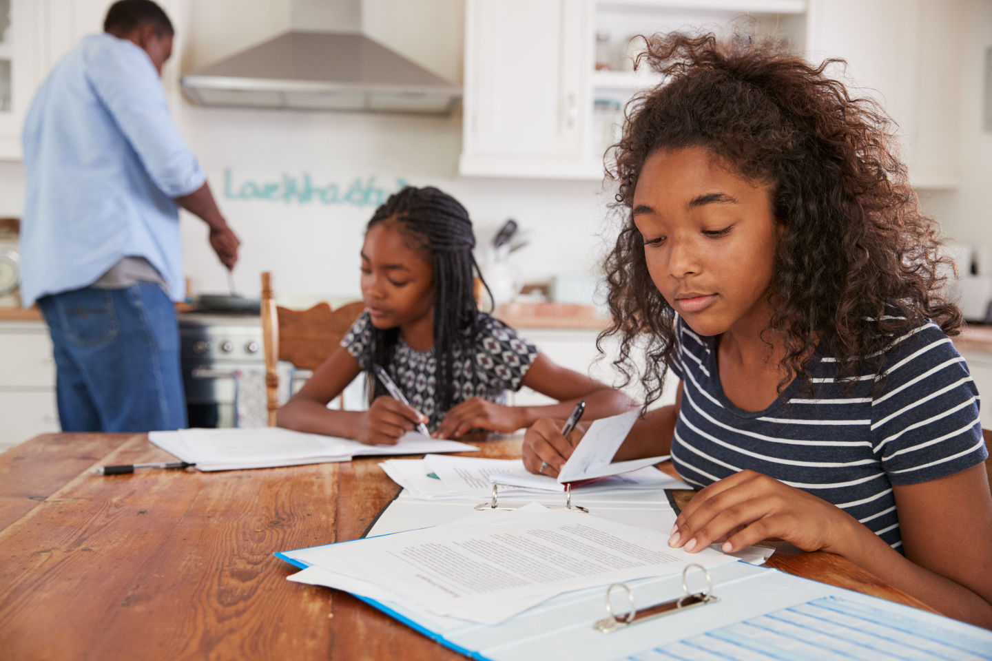 Kids doing homework at dinner table